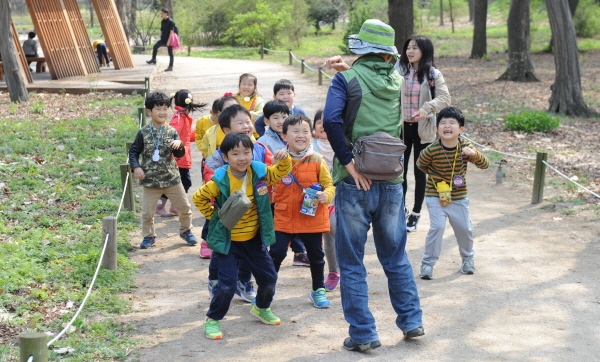 아이들이 홍릉근린공원 유아숲체험장에서 숲 해설가와 신체 활동을 하고 있다.