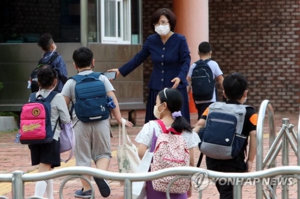 한 초등학교에서 교장 선생님이 학생을 맞이하고 있다. [사진=연합뉴스]
